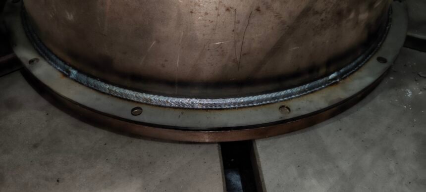 Close-up of a uniform robot weld bead on a steel vessel flange at xLogic's dark factory