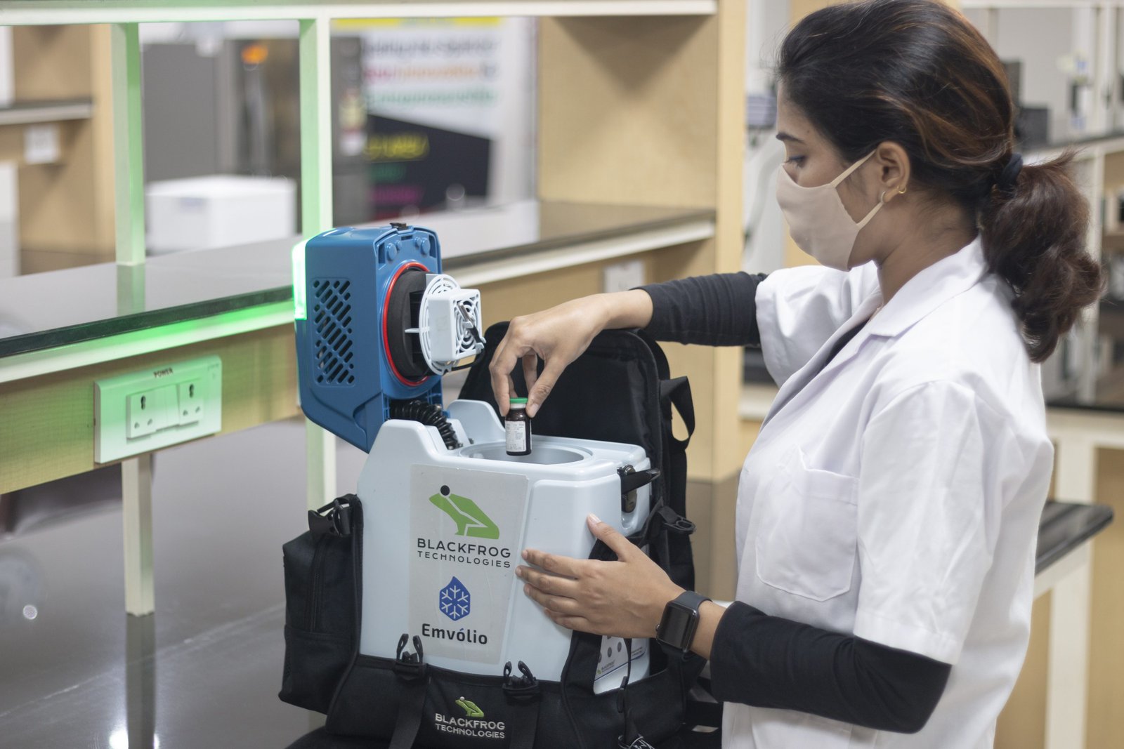 A health worker loads a vaccine vial into Emvólio, Blackfrog's portable battery-powered refrigerator
