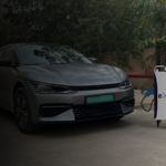 Cargar's eX10sn portable DC fast charger on its trolley, charging a parked electric car