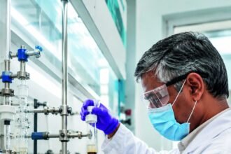 NuSynth process chemist running a column in the company fume hood