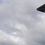 Antenna tower with microwave dishes under a cloudy sky, 1200x630 cover