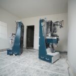 Two Centa Painter robots working in an unfinished room on a construction site