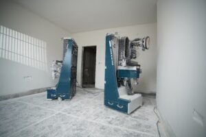 Two Centa Painter robots working in an unfinished room on a construction site