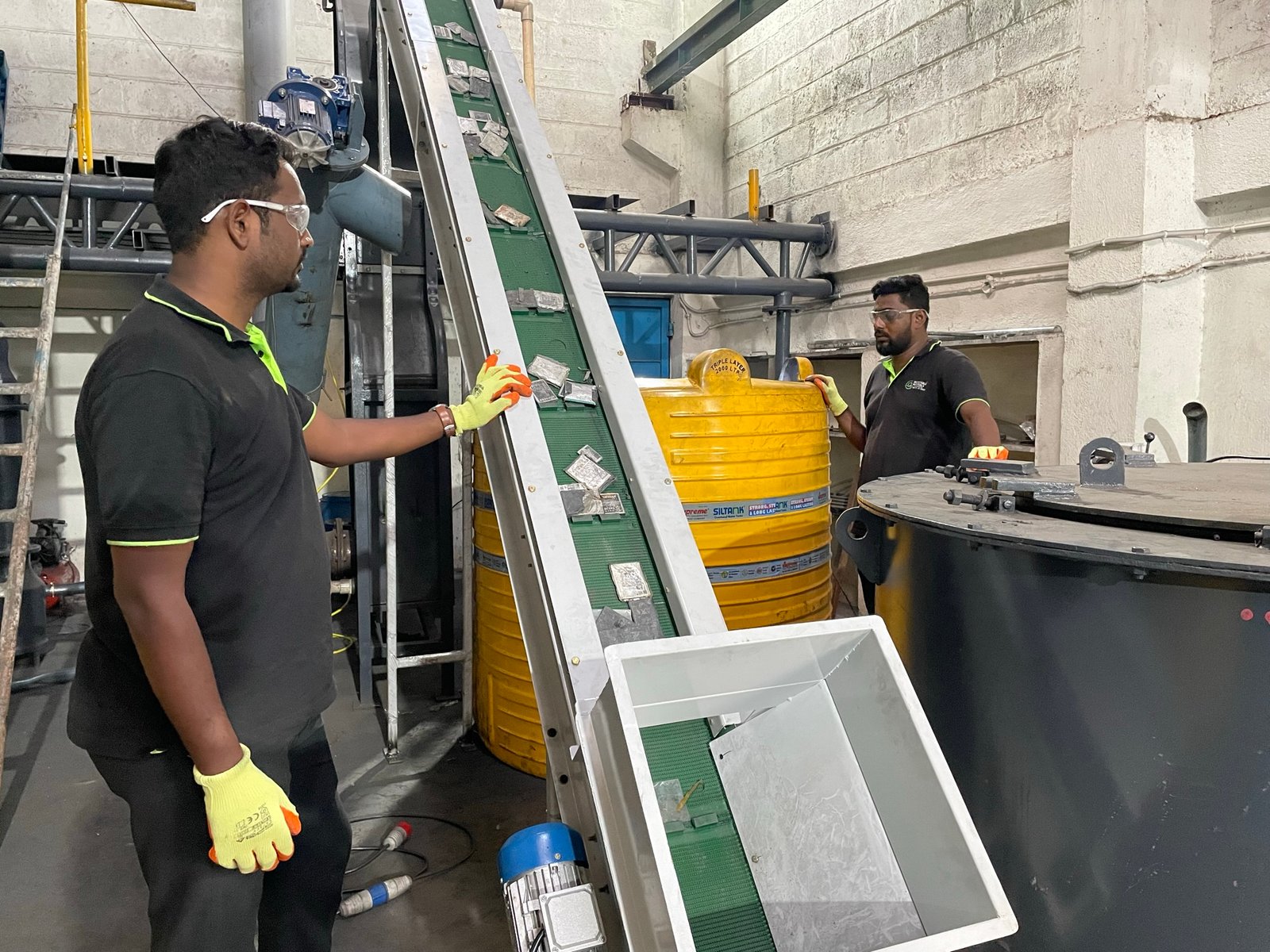 Workers feeding spent battery cells at Metastable Materials’ Bengaluru plant