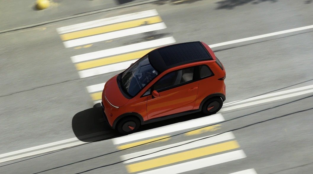 Vayve Mobility Eva with its solar roof panel, driving through a city street